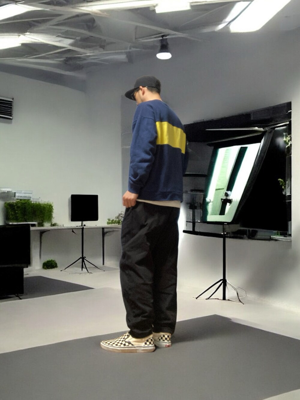 ブラック系のデニムパンツ、ホワイト系のスリッポン、ブルー系のスウェットを着用したメンズの春コーディネートの3枚目の写真