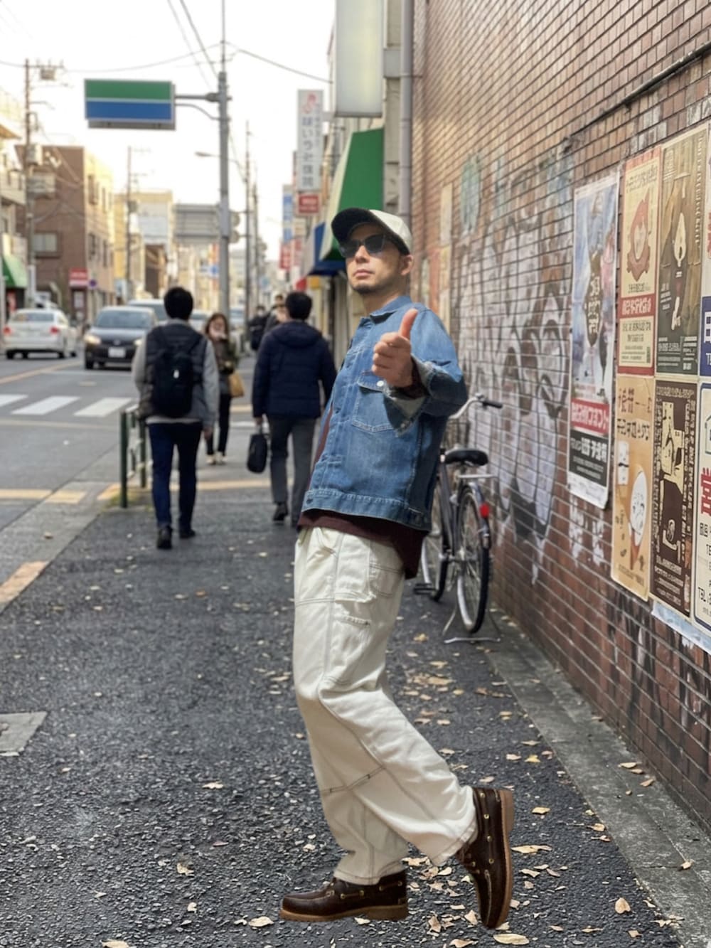 ブラウン系のモカシン/デッキシューズ、レッド系のTシャツ/カットソー、ブルー系のデニムジャケットを着用したメンズの春コーディネートの3枚目の写真