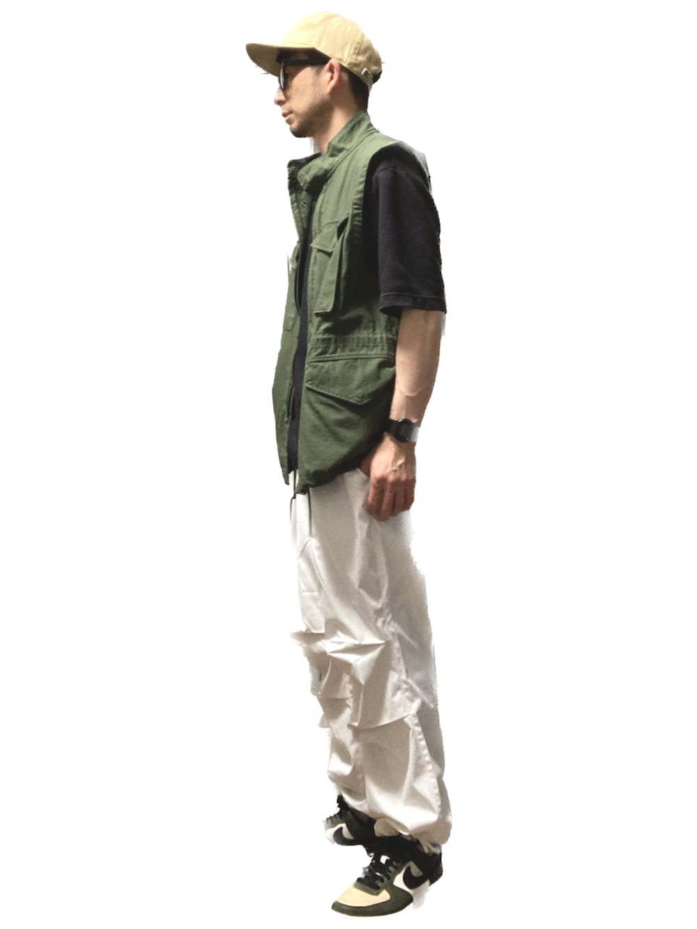 ホワイト系のカーゴパンツ、グリーン系のスニーカー、グリーン系のベストを着用したメンズの夏コーディネートの2枚目の写真