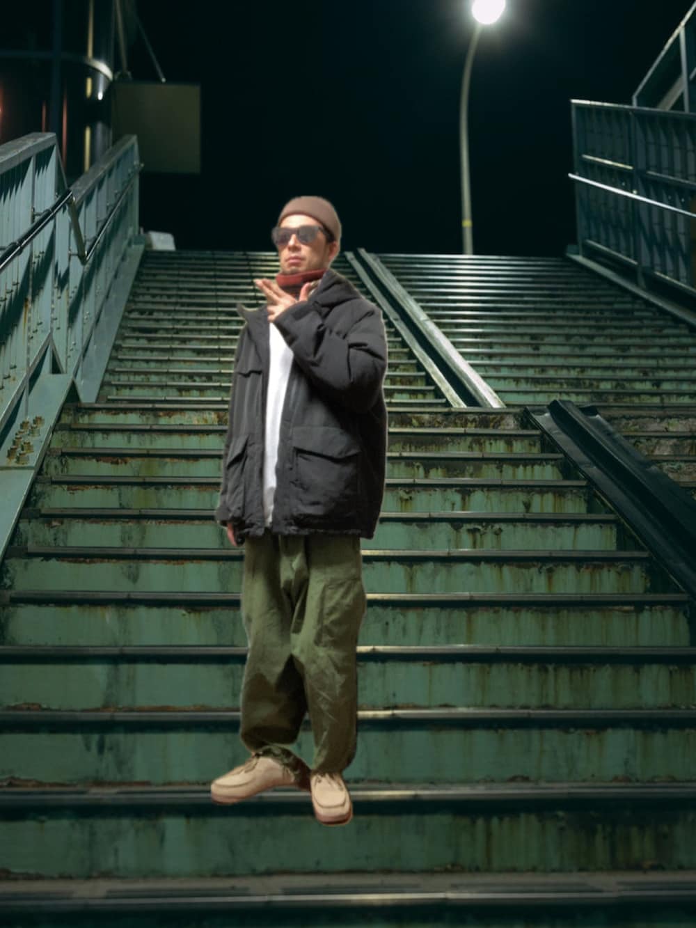 ブラック系のマウンテンパーカー、ホワイト系のスウェット、グリーン系のカーゴパンツを着用したメンズの冬コーディネートの2枚目の写真