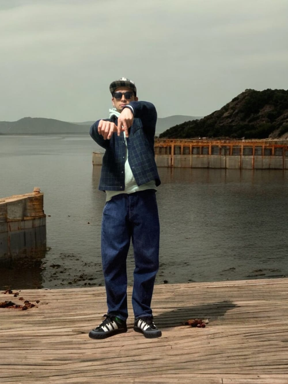 ブラック系のスニーカー、ブルー系のその他アウター、グリーン系のパーカーを着用したメンズの春コーディネートの4枚目の写真