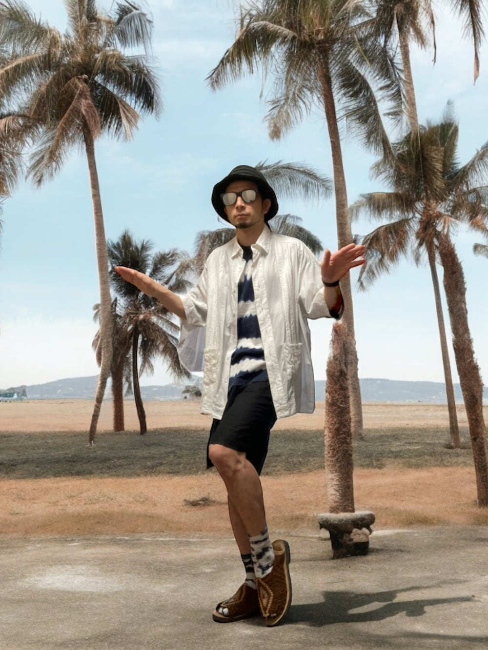 ブラウン系のサンダル、ブラック系のその他パンツ、ブルー系のTシャツ/カットソーを着用したメンズの夏コーディネートの4枚目の写真