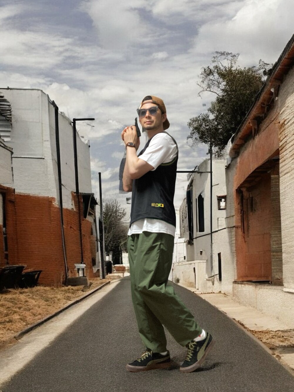 ブラック系のスニーカー、ブラック系のタンクトップ、グリーン系のスラックスを着用したメンズの夏コーディネートの4枚目の写真