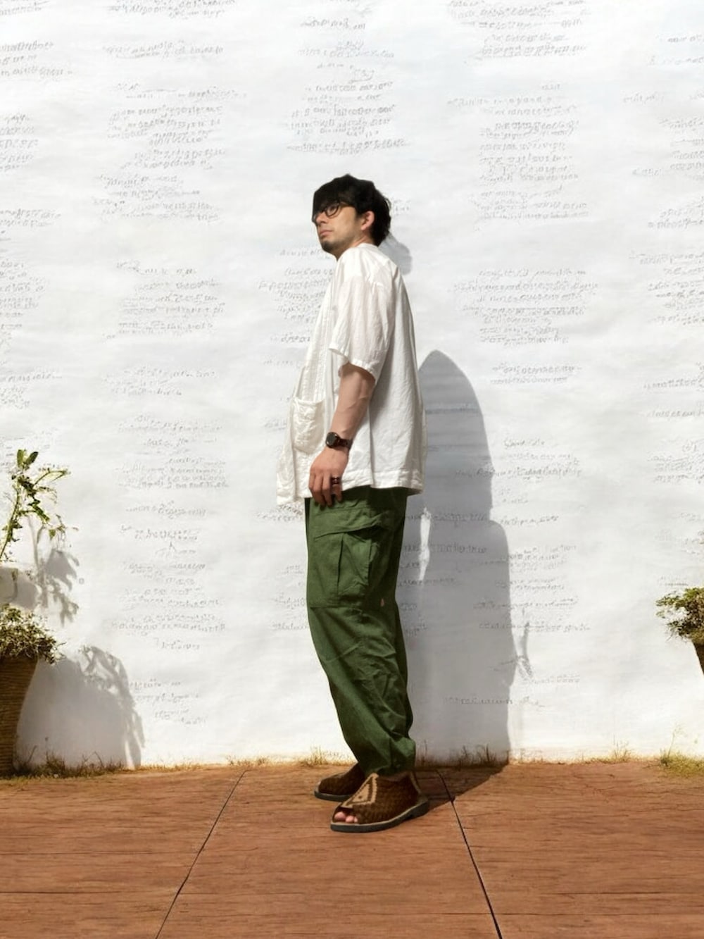 グレー系のタンクトップ、グリーン系のカーゴパンツ、ホワイト系のシャツ/ブラウスを着用したメンズの夏コーディネートの3枚目の写真