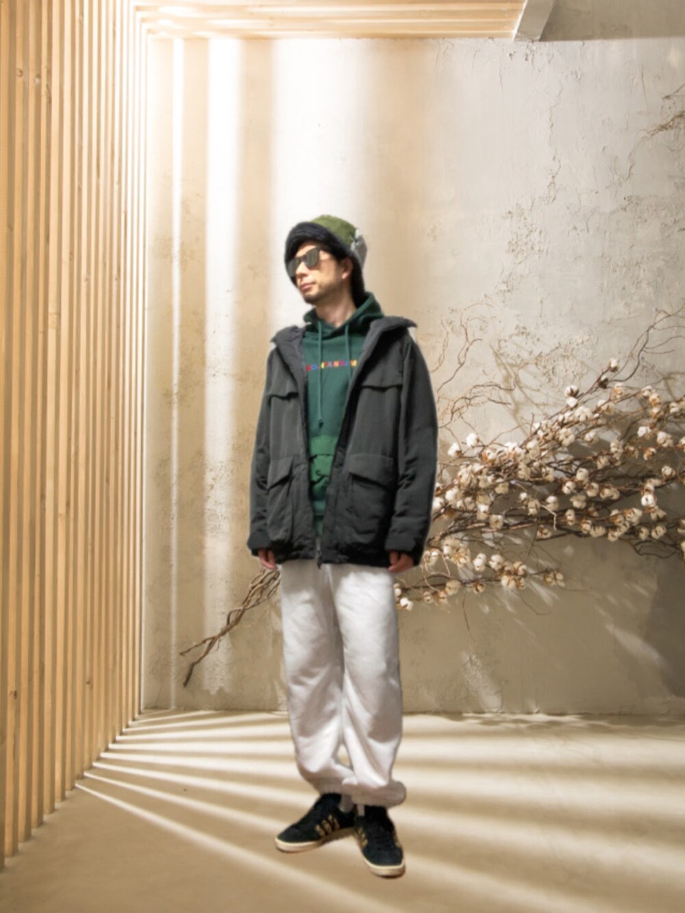 ホワイト系のスウェットパンツ、ブラック系のスニーカー、グリーン系のパーカーを着用したメンズの冬コーディネートの3枚目の写真