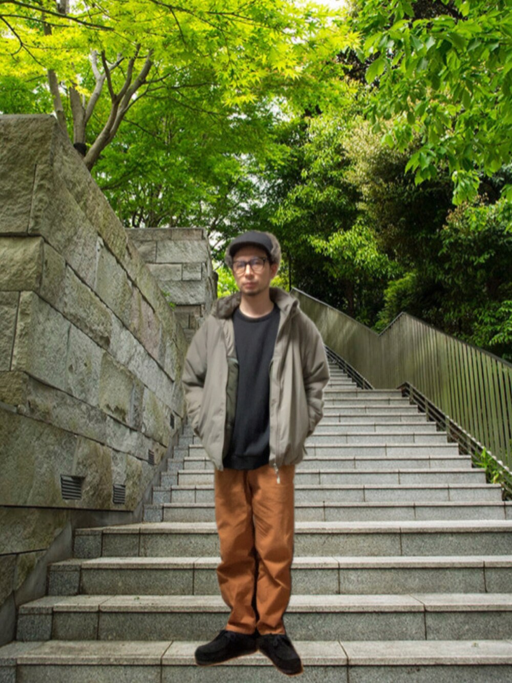 ブラウン系のチノパンツ、ブラック系のモカシン/デッキシューズ、グレー系のミリタリージャケットを着用したメンズの冬コーディネートの3枚目の写真