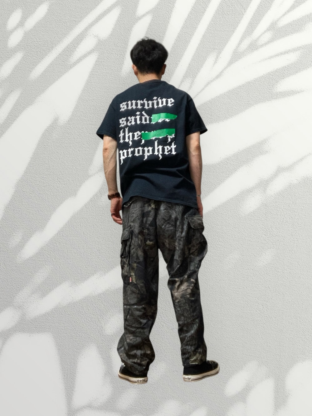 ブラック系のスニーカー、ブラック系のカーゴパンツ、ブラック系のTシャツ/カットソーを着用したメンズの夏コーディネートの2枚目の写真
