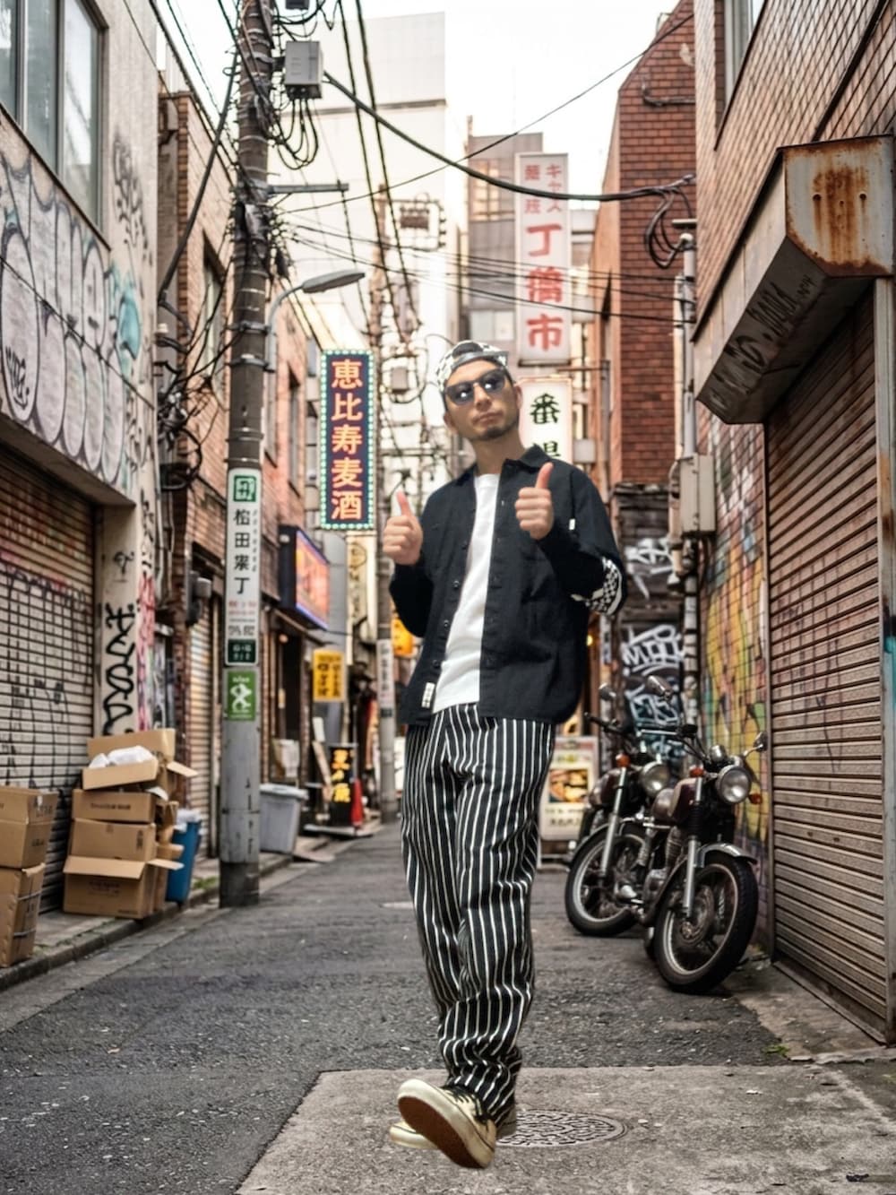 ブラック系のシャツ/ブラウス、ブラック系のチノパンツ、ホワイト系のスニーカーを着用したメンズの春コーディネートの4枚目の写真