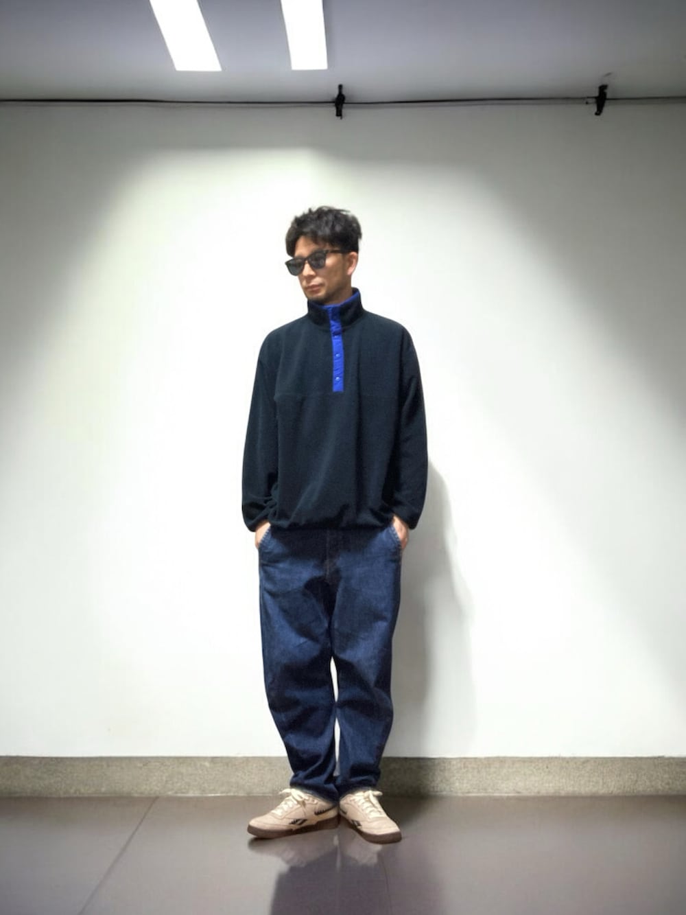 ベージュ系のスニーカー、その他のミリタリージャケット、ブルー系のデニムパンツを着用したメンズの冬コーディネートの5枚目の写真