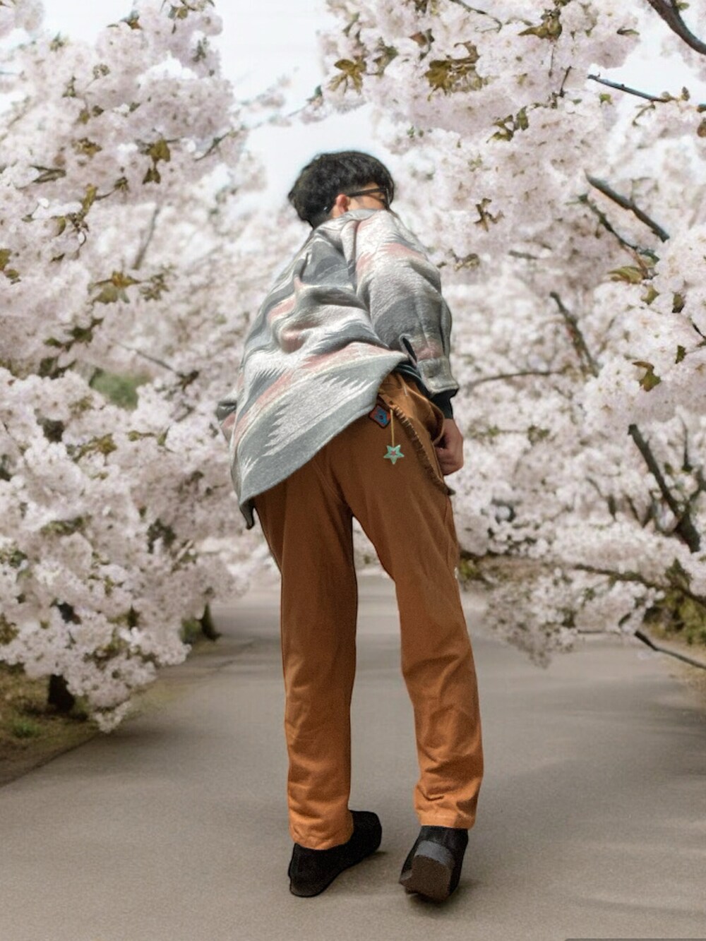 ブラウン系のチノパンツ、ブラック系のモカシン/デッキシューズ、グリーン系のTシャツ/カットソーを着用したメンズの春コーディネートの4枚目の写真