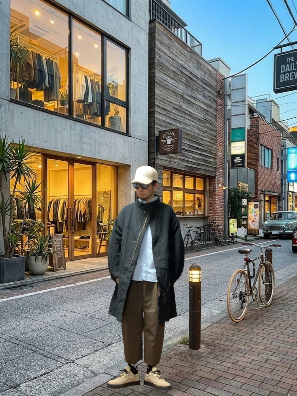 ブラック系のモッズコート、ブルー系のシャツ/ブラウス、ブラウン系のスラックスを着用したメンズの春コーディネートの2枚目の写真