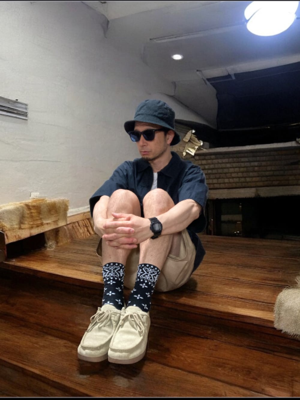 ブラック系のシャツ/ブラウス、ベージュ系のチノパンツ、ベージュ系のモカシン/デッキシューズを着用したメンズの秋コーディネートの5枚目の写真