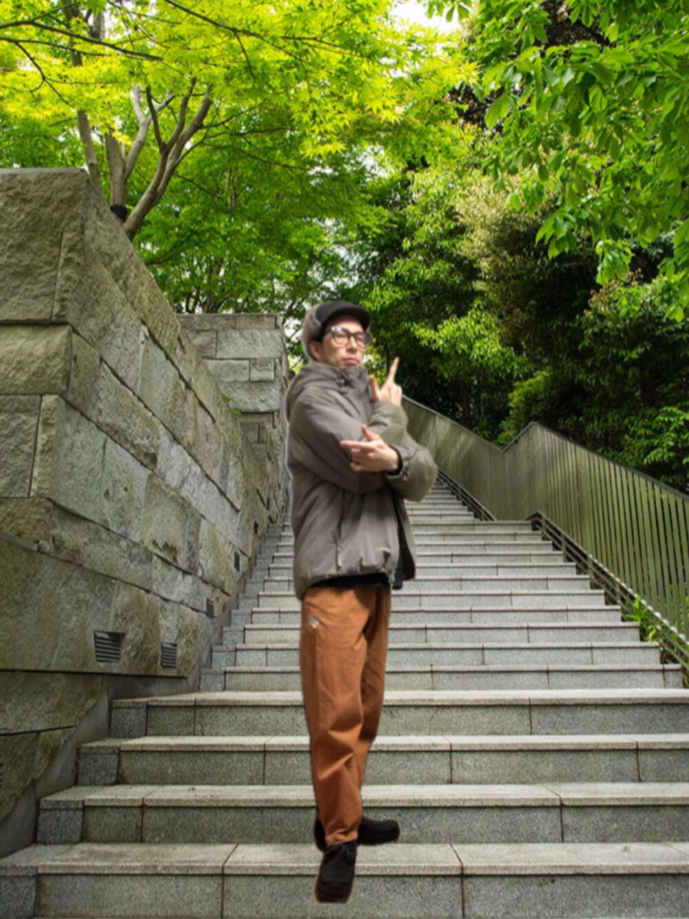 ブラウン系のチノパンツ、ブラック系のモカシン/デッキシューズ、グレー系のミリタリージャケットを着用したメンズの冬コーディネートの4枚目の写真