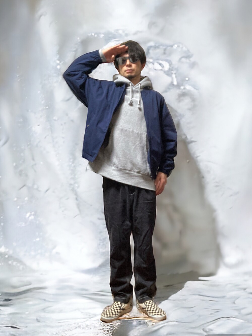 ブラック系のチノパンツ、ブルー系のノーカラージャケット、グレー系のパーカーを着用したメンズの春コーディネートの4枚目の写真