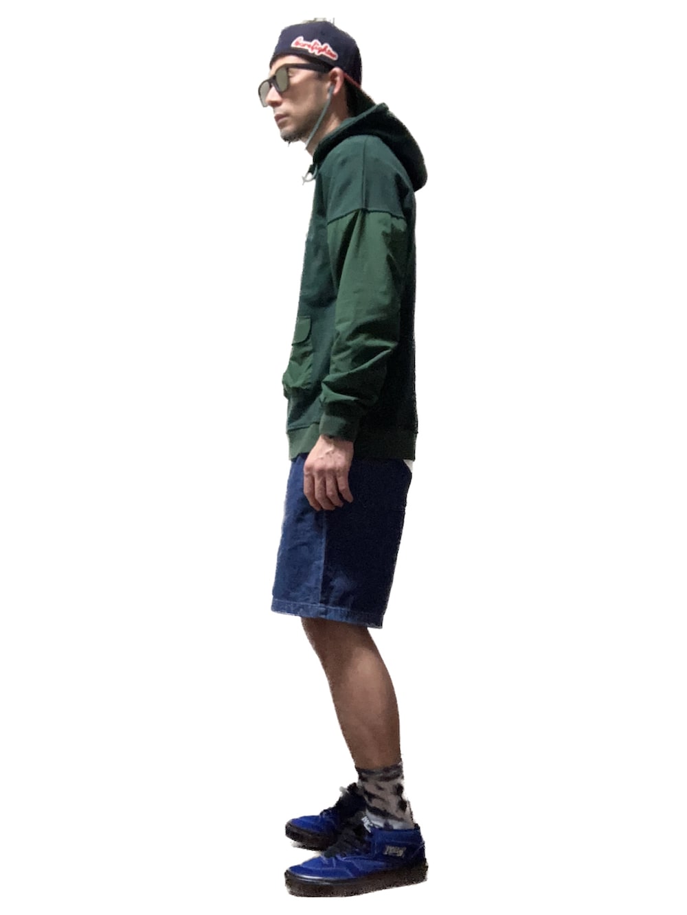 グリーン系のパーカー、ブルー系のデニムパンツ、ブルー系のスニーカーを着用したメンズの秋コーディネートの3枚目の写真