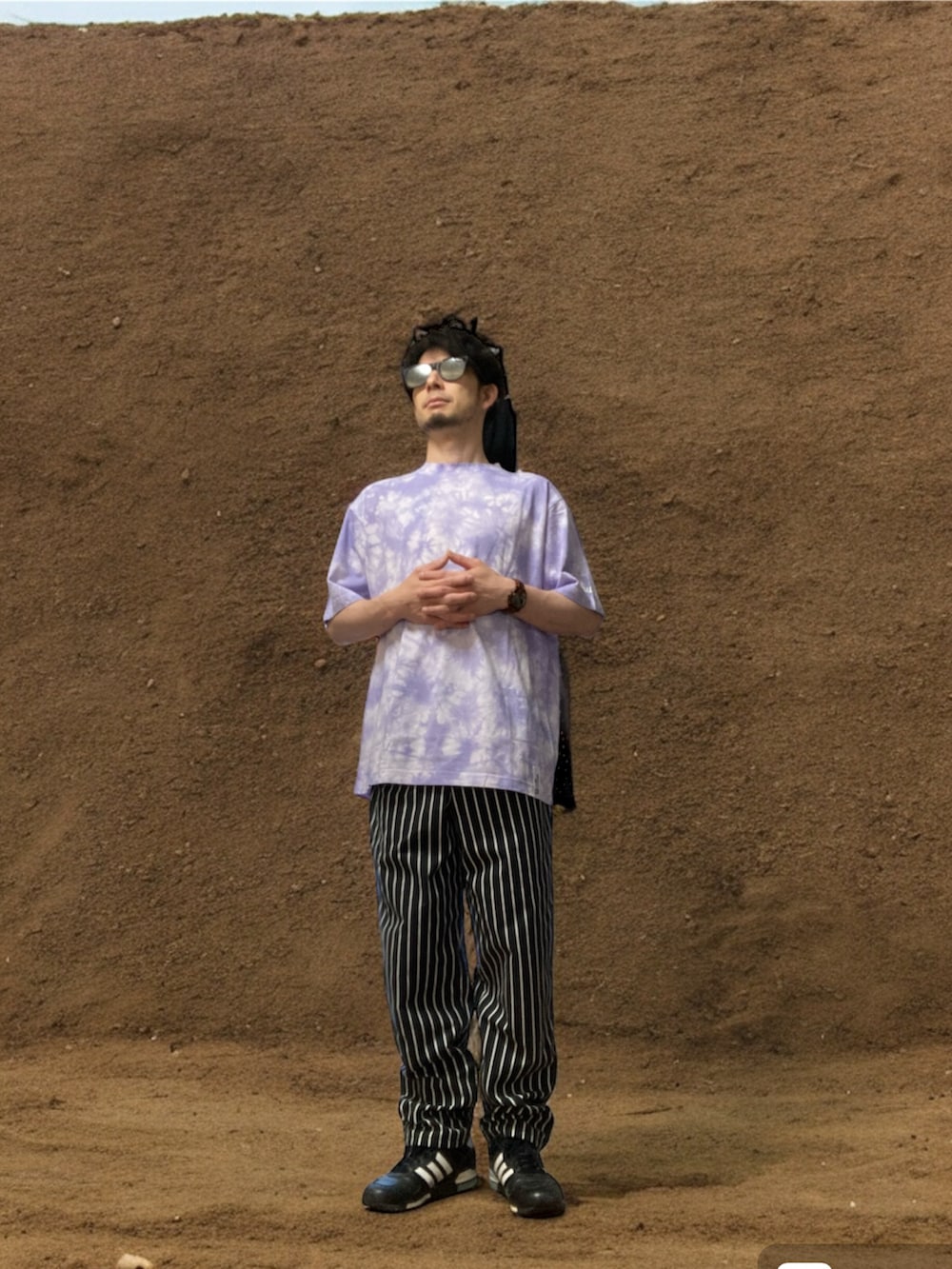 パープル系のTシャツ/カットソー、ブラック系のチノパンツ、ブラック系のスニーカーを着用したメンズの夏コーディネートの2枚目の写真