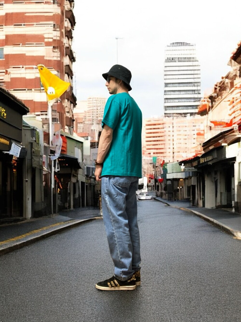 ブルー系のデニムパンツ、ブラック系のスニーカー、グリーン系のTシャツ/カットソーを着用したメンズの夏コーディネートの2枚目の写真