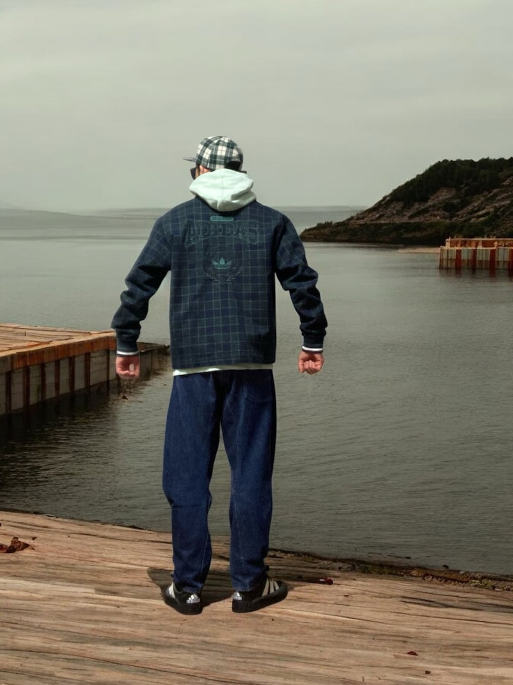 ブラック系のスニーカー、ブルー系のその他アウター、グリーン系のパーカーを着用したメンズの春コーディネートの3枚目の写真