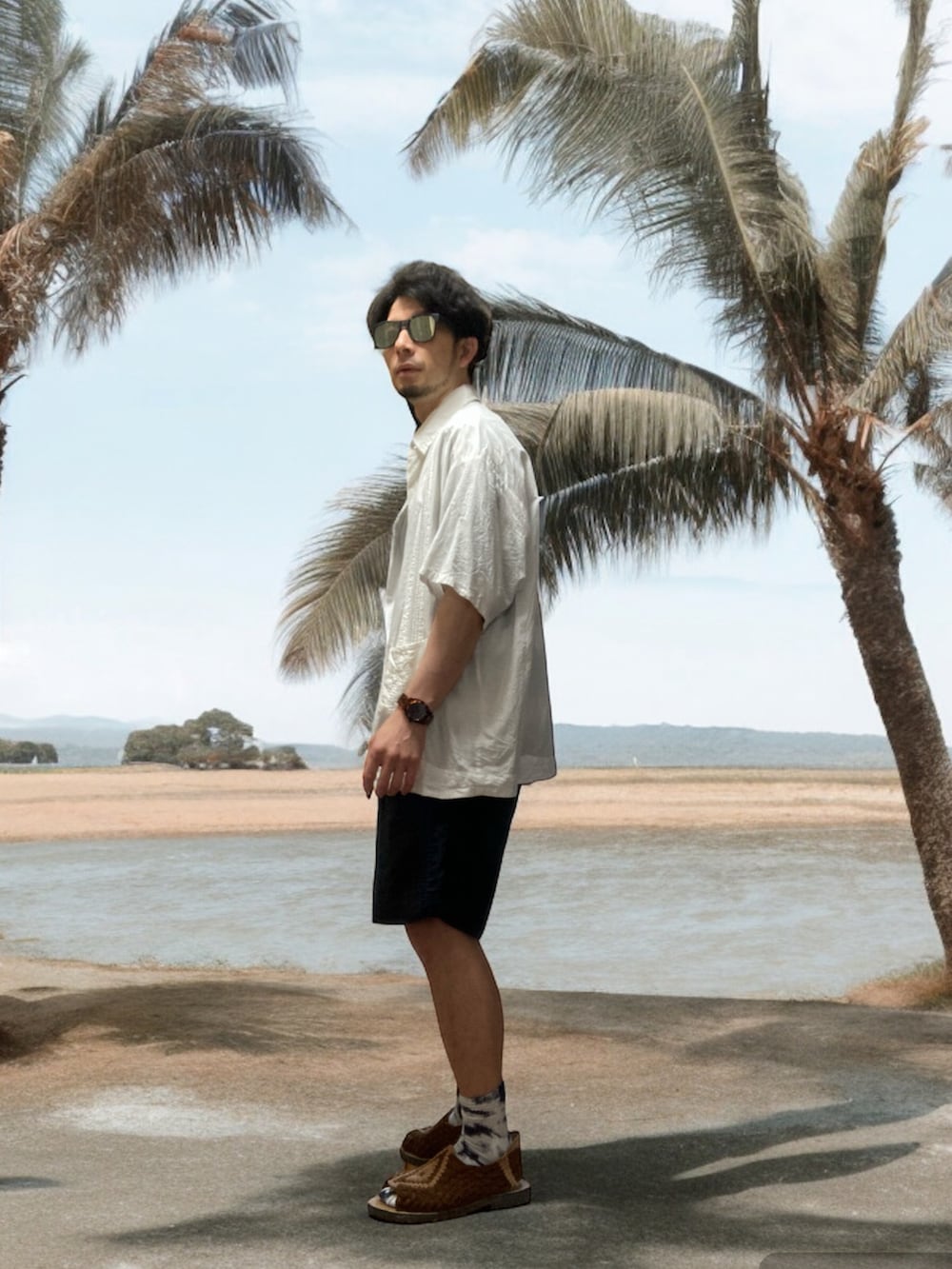 ブラウン系のサンダル、ブラック系のその他パンツ、ブルー系のTシャツ/カットソーを着用したメンズの夏コーディネートの2枚目の写真
