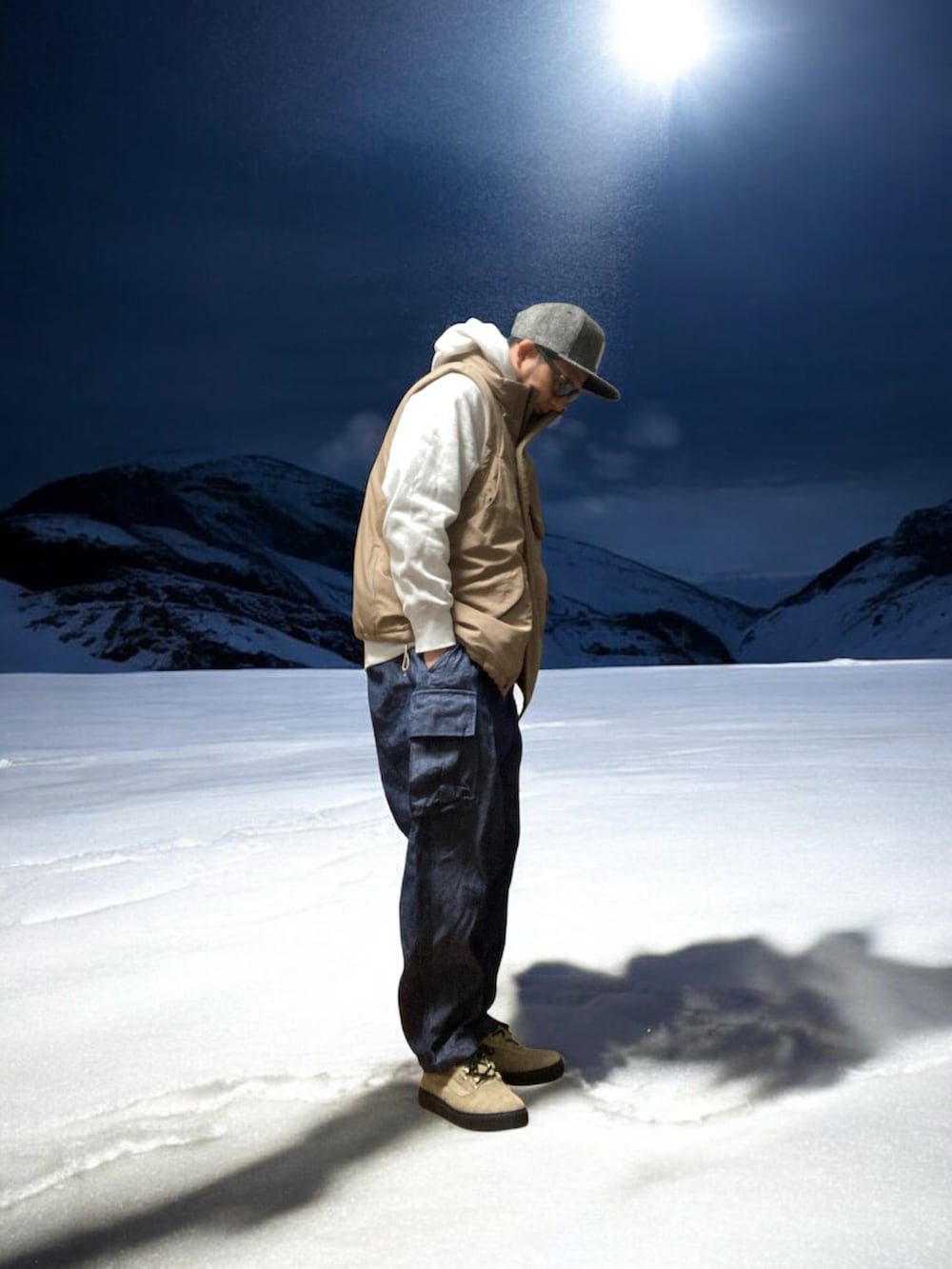 ブルー系のカーゴパンツ、ホワイト系のパーカー、ベージュ系のダウンベストを着用したメンズの冬コーディネートの3枚目の写真