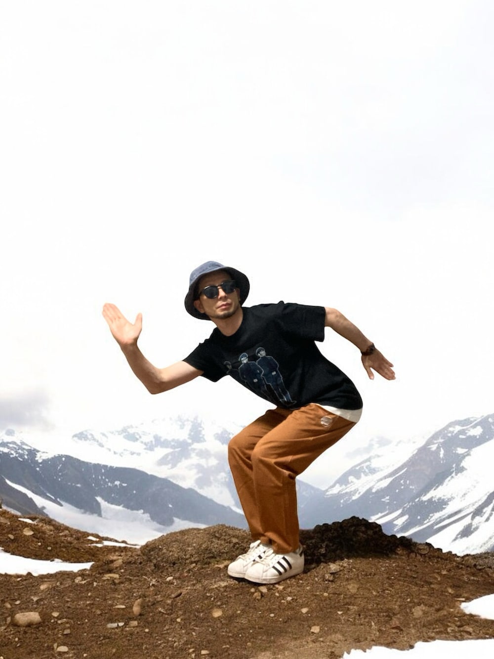 ブラウン系のチノパンツ、ホワイト系のスニーカー、ブラック系のTシャツ/カットソーを着用したメンズの秋コーディネートの5枚目の写真