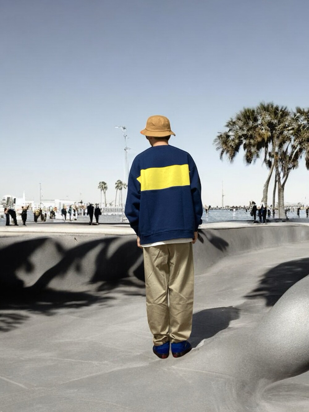 ベージュ系のチノパンツ、ブルー系のスニーカー、ブルー系のスウェットを着用したメンズの秋コーディネートの4枚目の写真