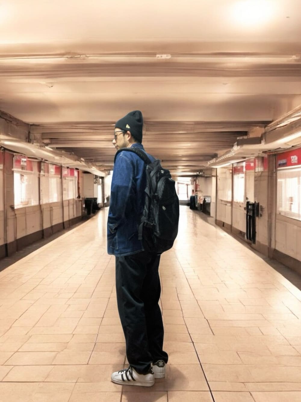 ブラック系のチノパンツ、グリーン系のスウェット、ホワイト系のスニーカーを着用したメンズの秋コーディネートの3枚目の写真