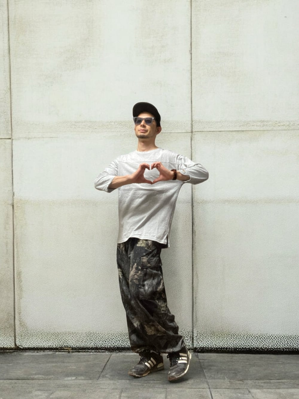 グレー系のTシャツ/カットソー、ブラック系のカーゴパンツ、ブラック系のスニーカーを着用したメンズの秋コーディネートの3枚目の写真