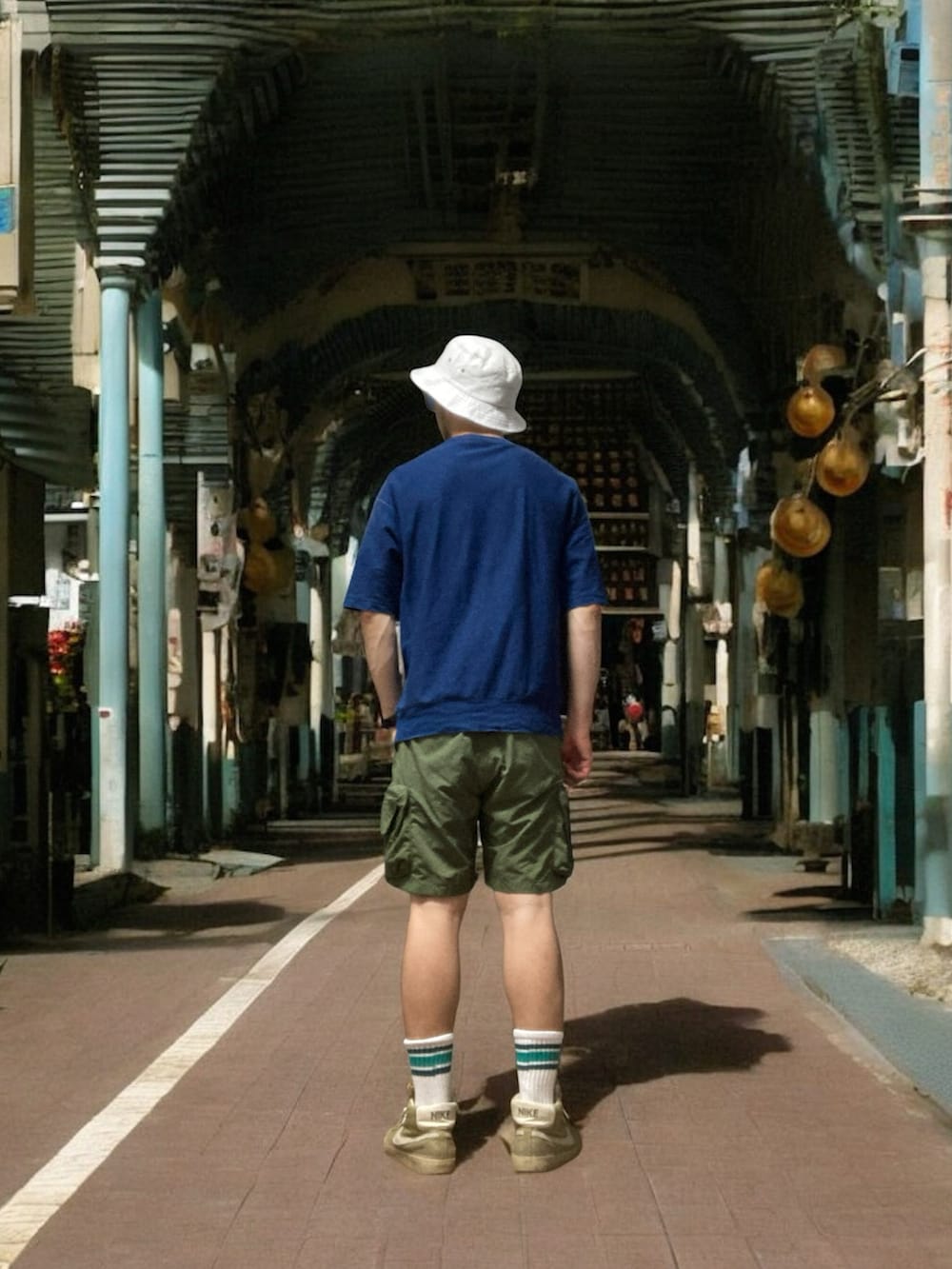 ブルー系のTシャツ/カットソー、グリーン系のカーゴパンツ、ベージュ系のスニーカーを着用したメンズの夏コーディネートの3枚目の写真