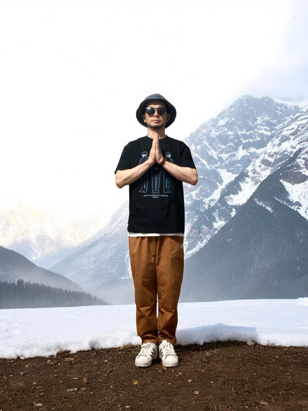 ブラウン系のチノパンツ、ホワイト系のスニーカー、ブラック系のTシャツ/カットソーを着用したメンズの秋コーディネートの3枚目の写真