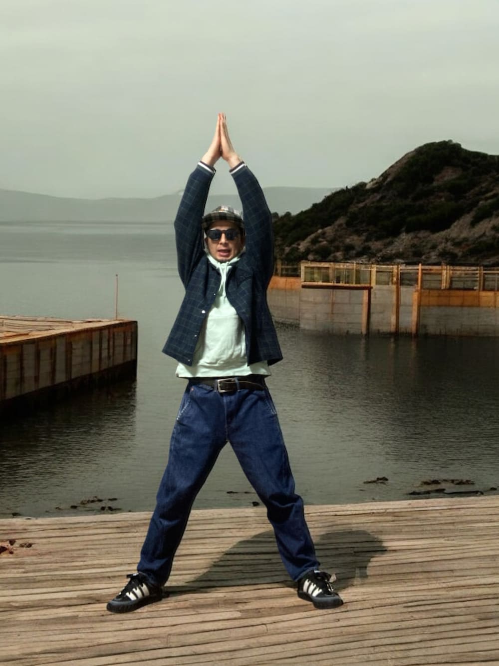 ブラック系のスニーカー、ブルー系のその他アウター、グリーン系のパーカーを着用したメンズの春コーディネートの5枚目の写真