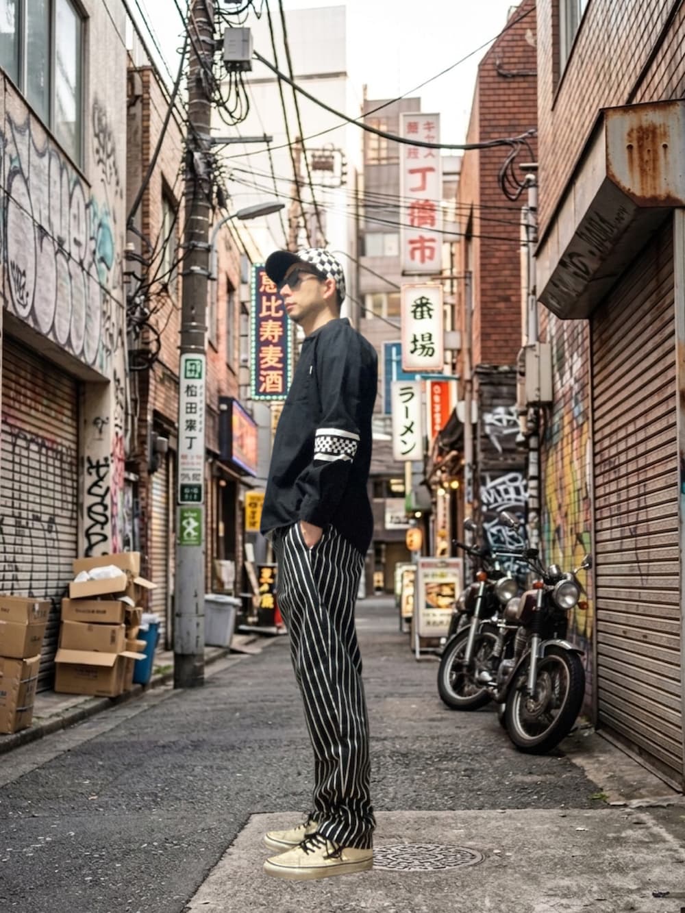 ブラック系のシャツ/ブラウス、ブラック系のチノパンツ、ホワイト系のスニーカーを着用したメンズの春コーディネートの3枚目の写真