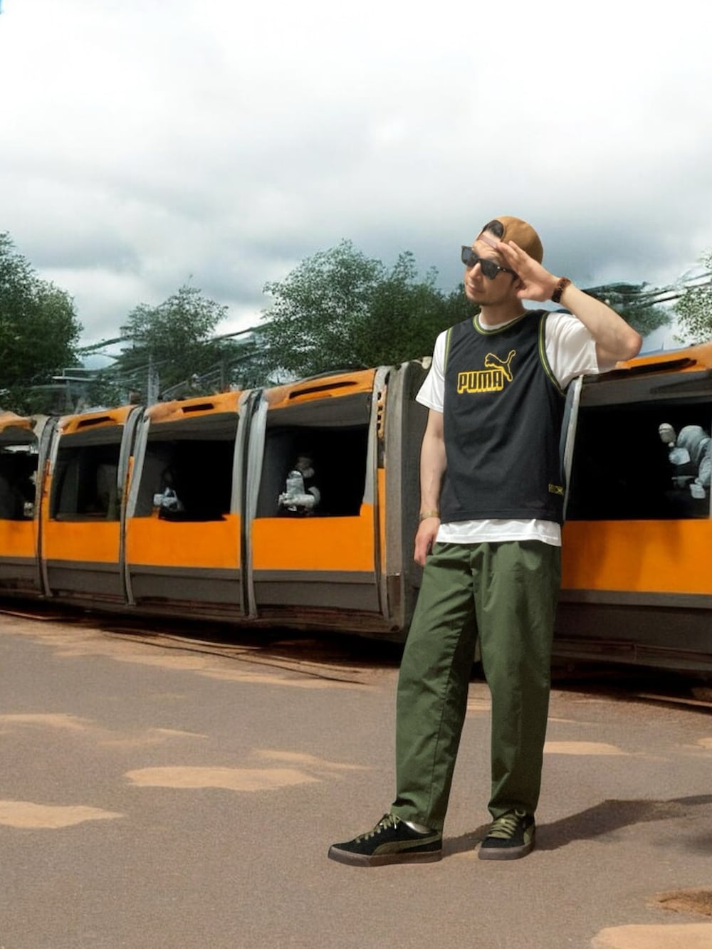 ブラック系のスニーカー、ブラック系のタンクトップ、グリーン系のスラックスを着用したメンズの夏コーディネートの3枚目の写真