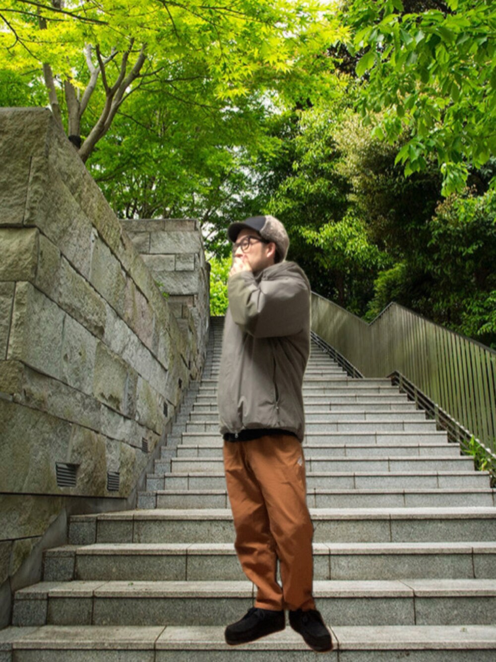 ブラウン系のチノパンツ、ブラック系のモカシン/デッキシューズ、グレー系のミリタリージャケットを着用したメンズの冬コーディネートの2枚目の写真