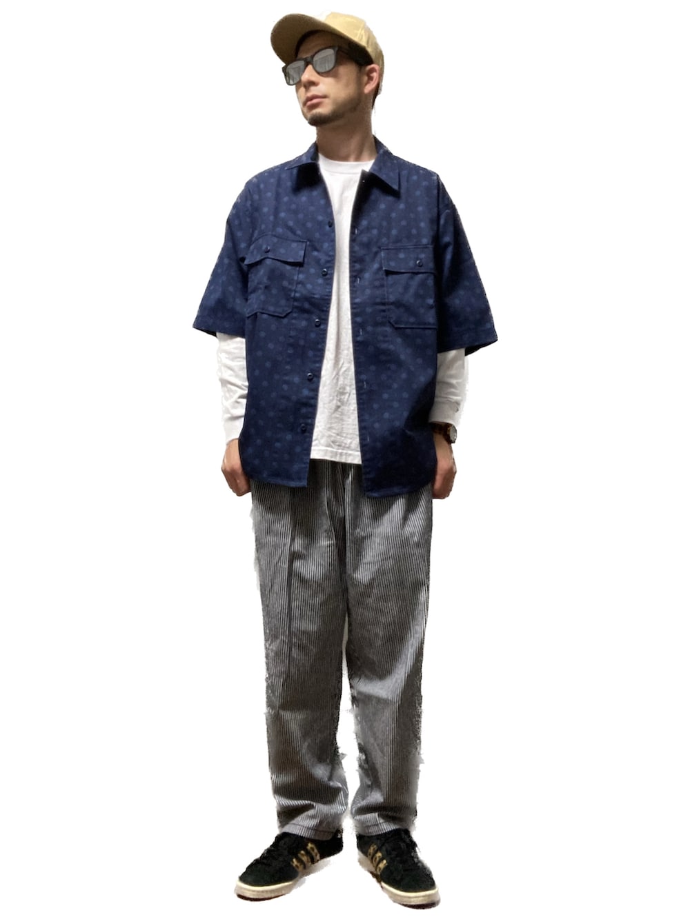 グレー系のチノパンツ、ブラック系のスニーカー、ホワイト系のTシャツ/カットソーを着用したメンズの春コーディネートの2枚目の写真