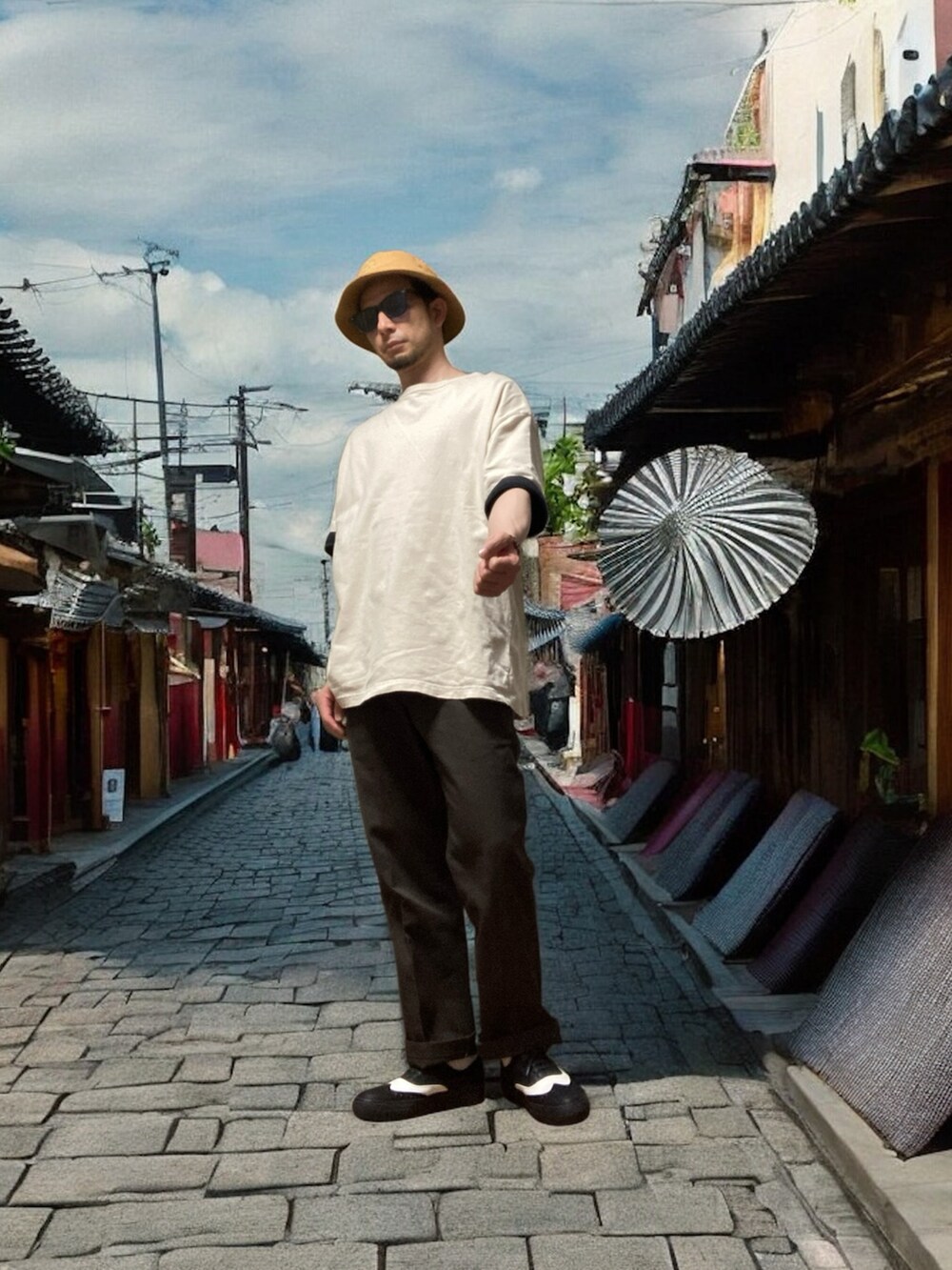 ブラウン系のチノパンツ、ベージュ系のTシャツ/カットソー、ブラック系のスニーカーを着用したメンズの夏コーディネートの2枚目の写真