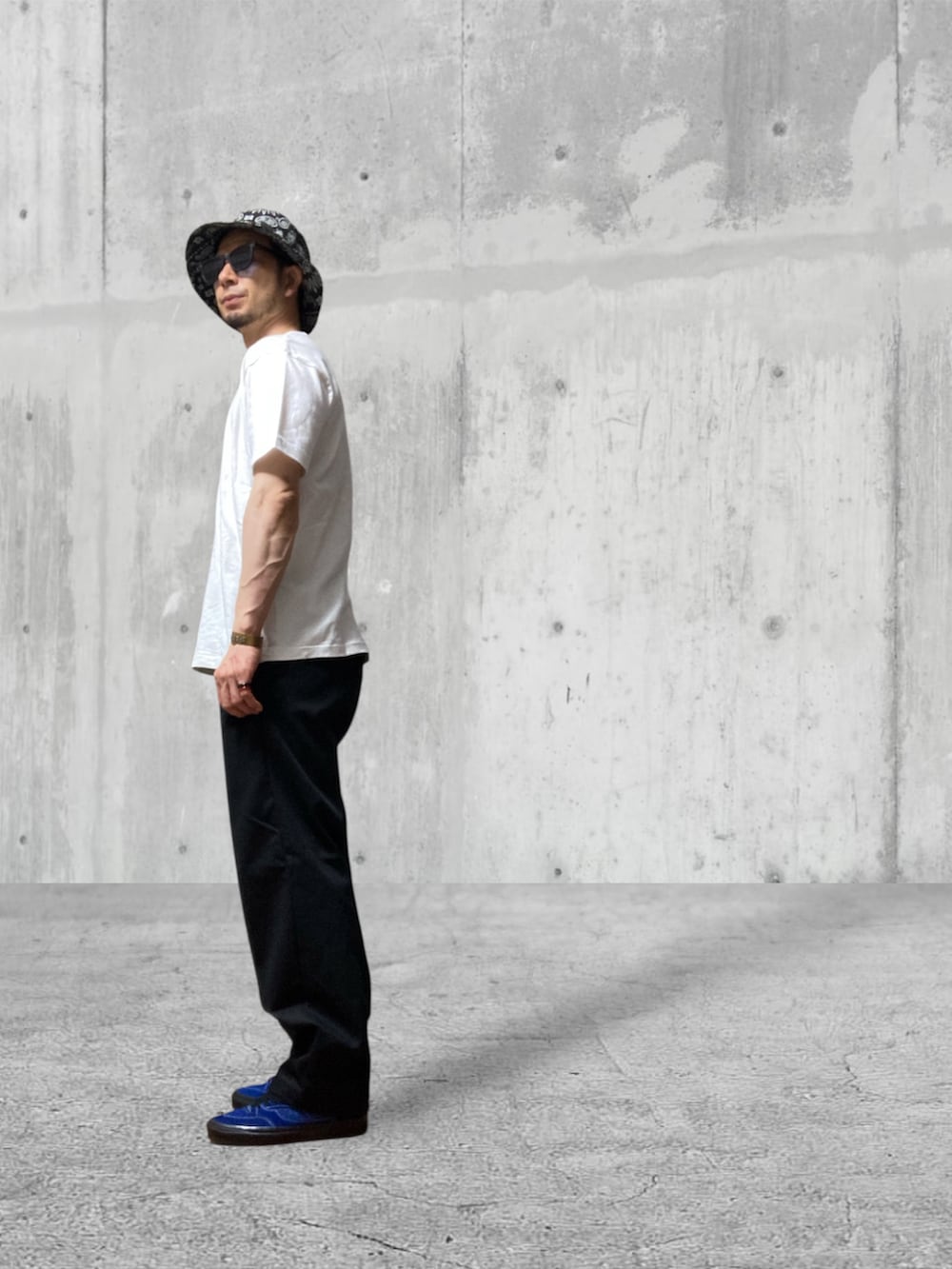 ブラック系のチノパンツ、ブルー系のスニーカー、ホワイト系のTシャツ/カットソーを着用したメンズの秋コーディネートの2枚目の写真