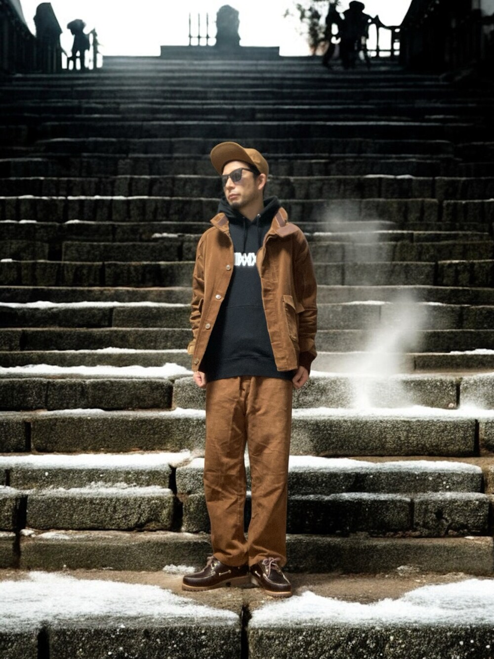 ブラック系のモッズコート、ブラウン系のその他パンツ、ブラウン系のモカシン/デッキシューズを着用したメンズの冬コーディネートの3枚目の写真