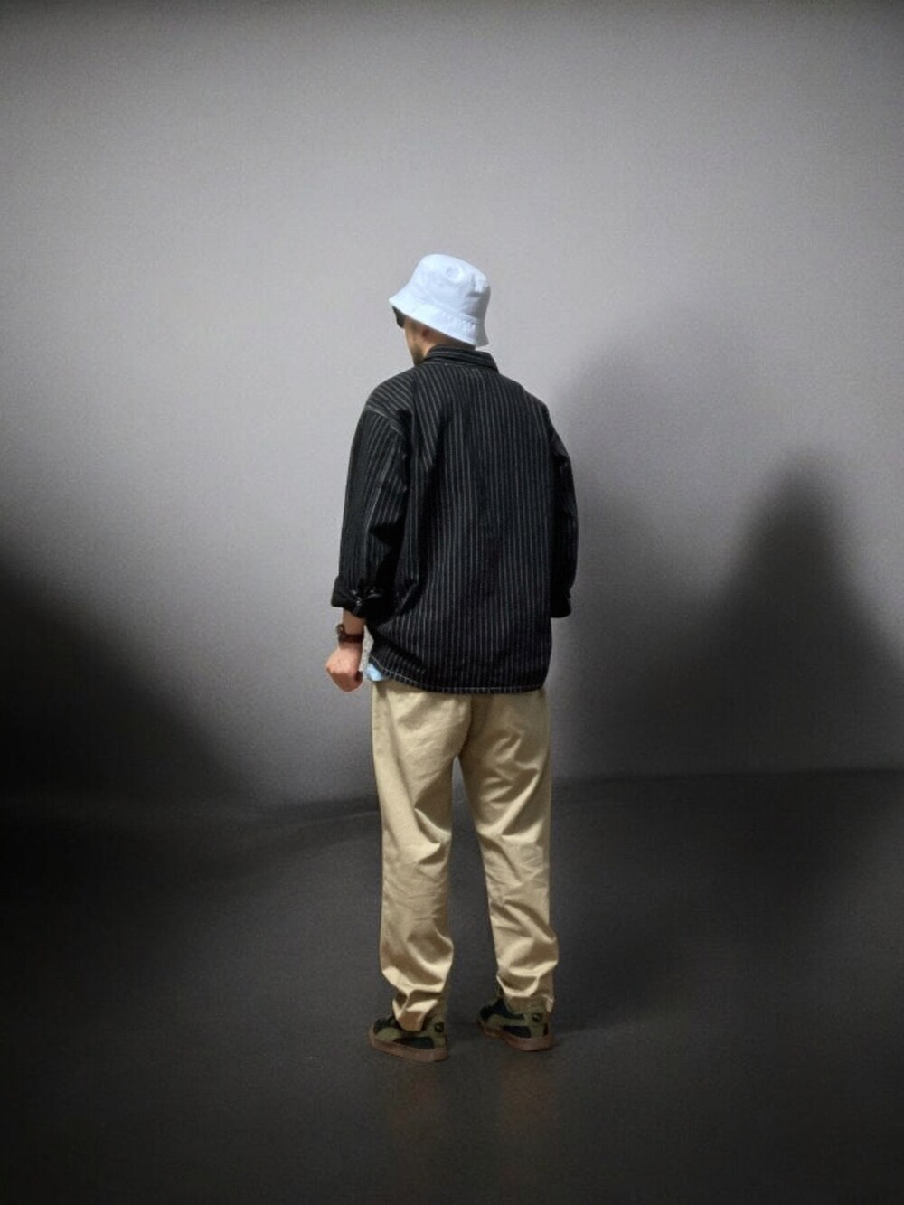 ブラック系のシャツ/ブラウス、ベージュ系のチノパンツ、ブラック系のスニーカーを着用したメンズの春コーディネートの3枚目の写真