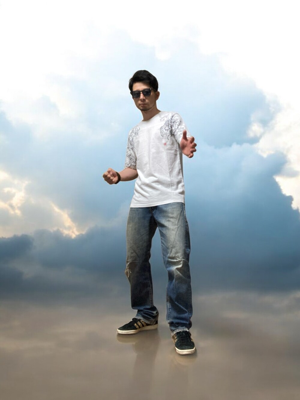 ブラック系のスニーカー、ホワイト系のTシャツ/カットソー、ブルー系のデニムパンツを着用したメンズの夏コーディネートの5枚目の写真