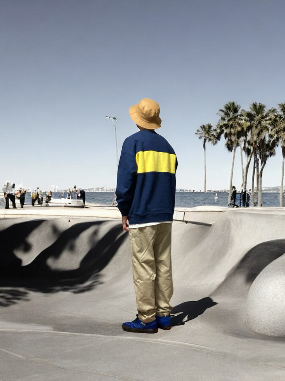 ベージュ系のチノパンツ、ブルー系のスニーカー、ブルー系のスウェットを着用したメンズの秋コーディネートの3枚目の写真