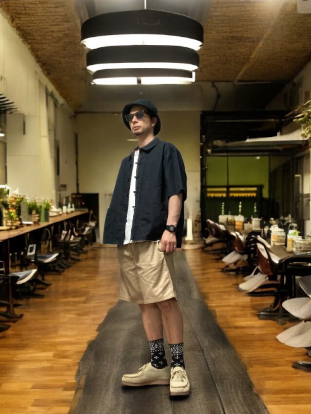 ブラック系のシャツ/ブラウス、ベージュ系のチノパンツ、ベージュ系のモカシン/デッキシューズを着用したメンズの秋コーディネートの2枚目の写真