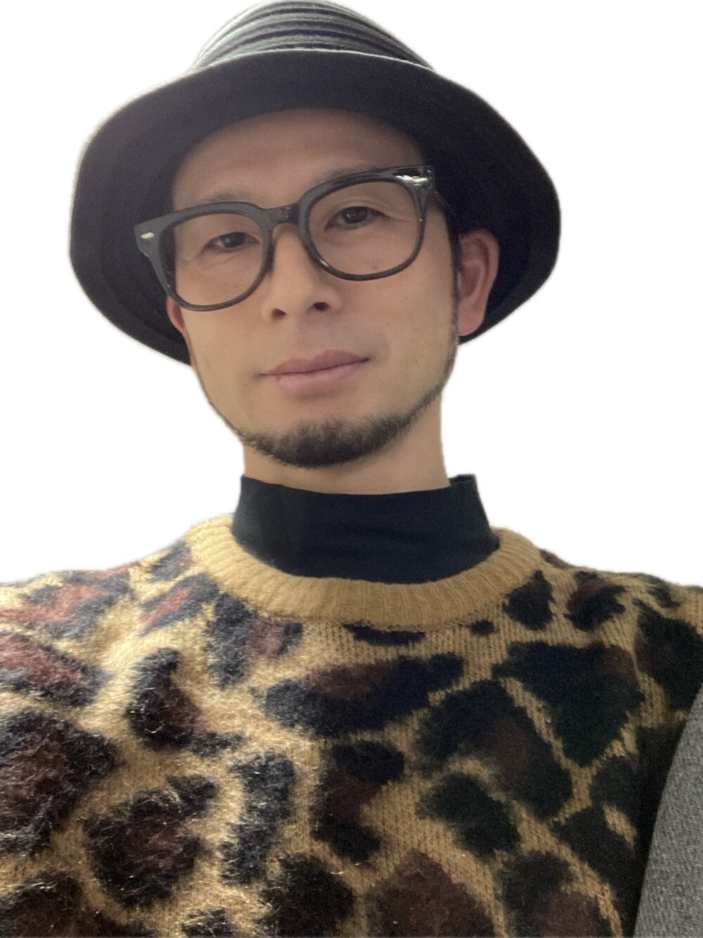 ホワイト系のチノパンツ、ブラック系のスニーカー、ベージュ系のニット/セーターを着用したメンズの冬コーディネートの5枚目の写真