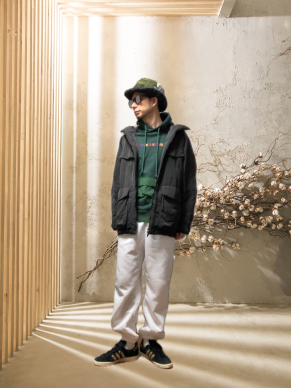 ホワイト系のスウェットパンツ、ブラック系のスニーカー、グリーン系のパーカーを着用したメンズの冬コーディネートの4枚目の写真