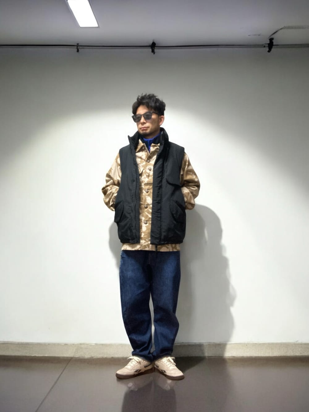 ベージュ系のスニーカー、その他のミリタリージャケット、ブルー系のデニムパンツを着用したメンズの冬コーディネートの2枚目の写真