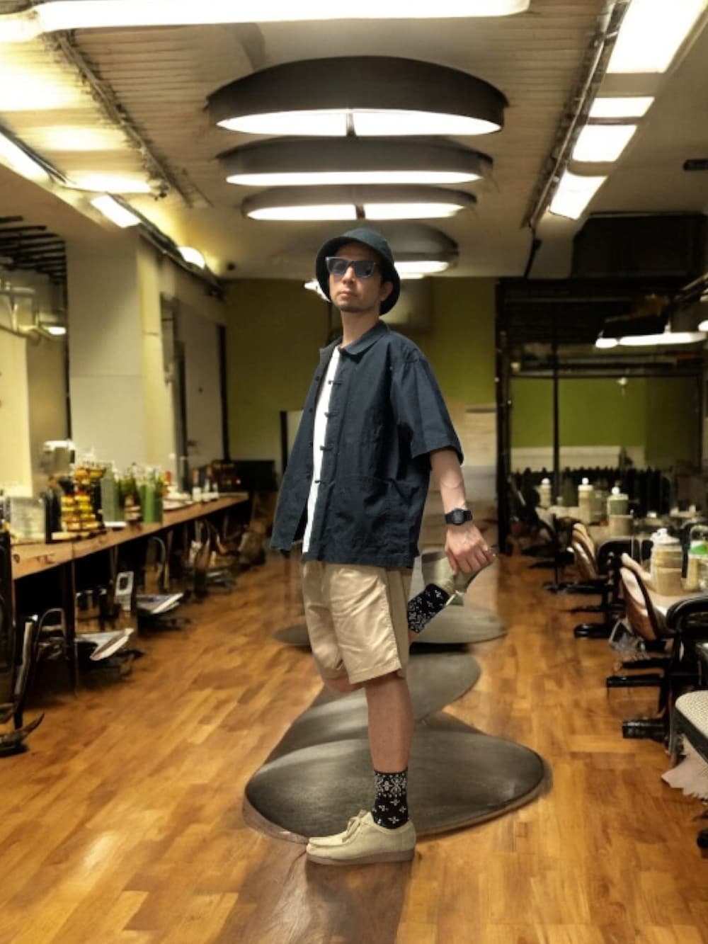 ブラック系のシャツ/ブラウス、ベージュ系のチノパンツ、ベージュ系のモカシン/デッキシューズを着用したメンズの秋コーディネートの4枚目の写真