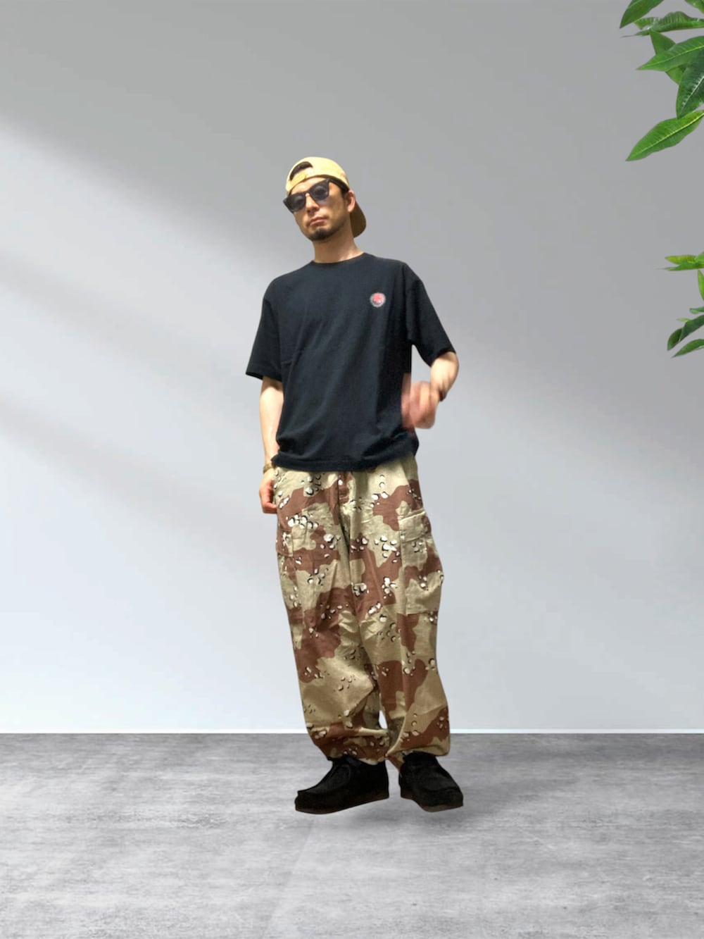 ベージュ系のカーゴパンツ、ブラック系のTシャツ/カットソー、ブラック系のモカシン/デッキシューズを着用したメンズの夏コーディネートの2枚目の写真