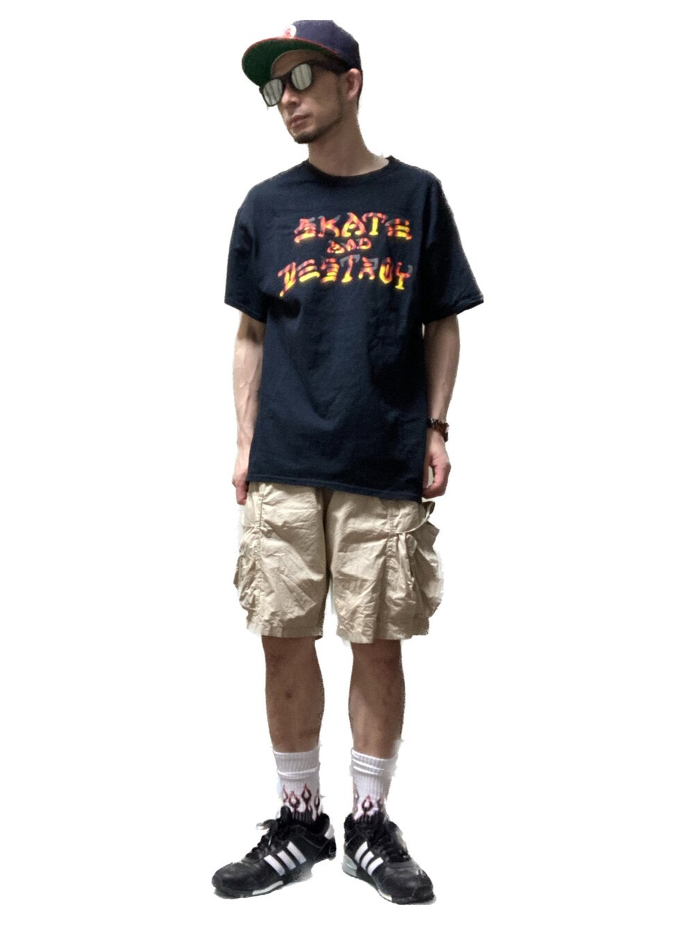 ブラック系のTシャツ/カットソー、ベージュ系のカーゴパンツ、ブラック系のスニーカーを着用したメンズの夏コーディネートの2枚目の写真