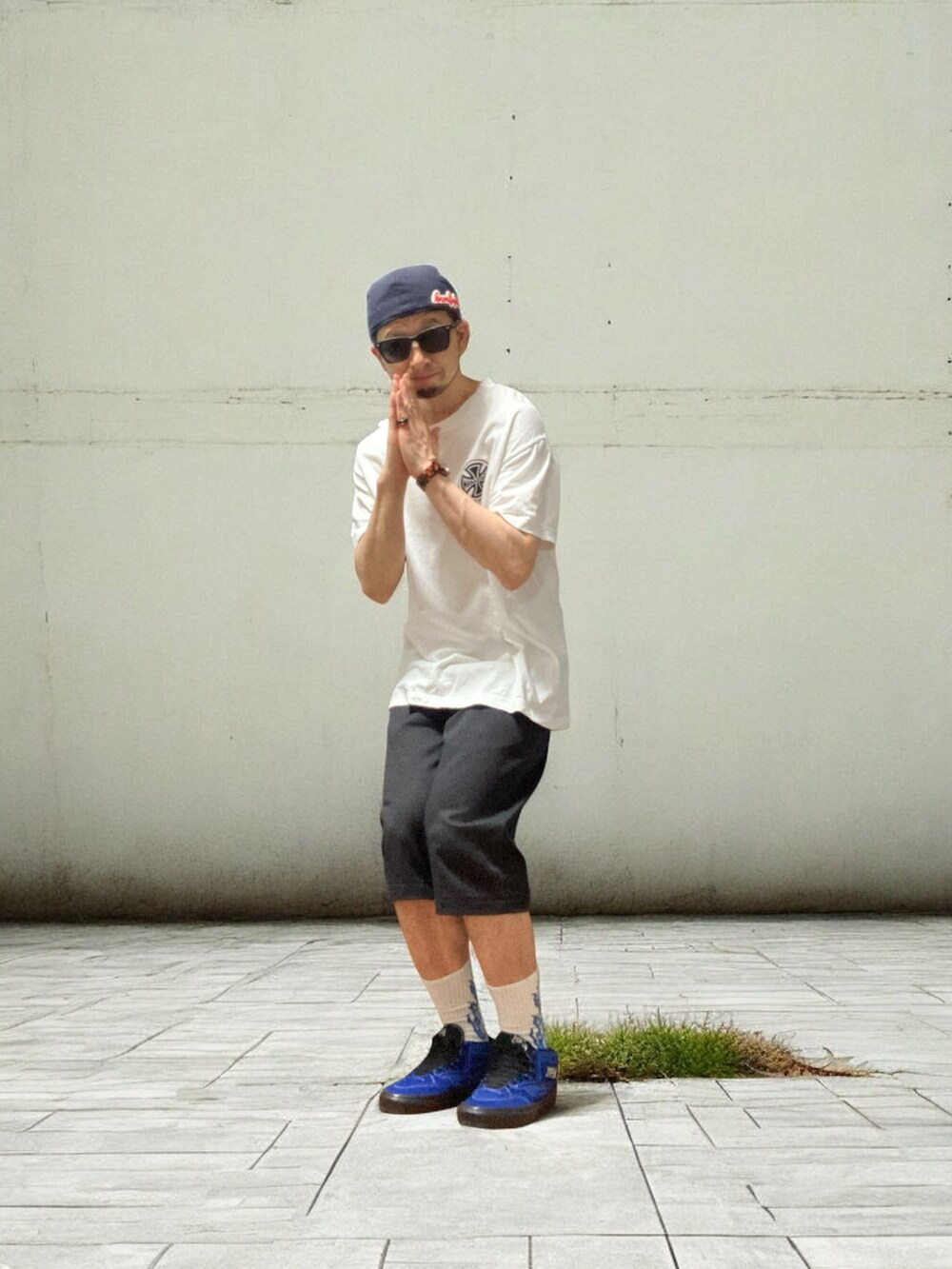 ホワイト系のTシャツ/カットソー、ブルー系のスニーカー、ブラック系のチノパンツを着用したメンズの夏コーディネートの4枚目の写真