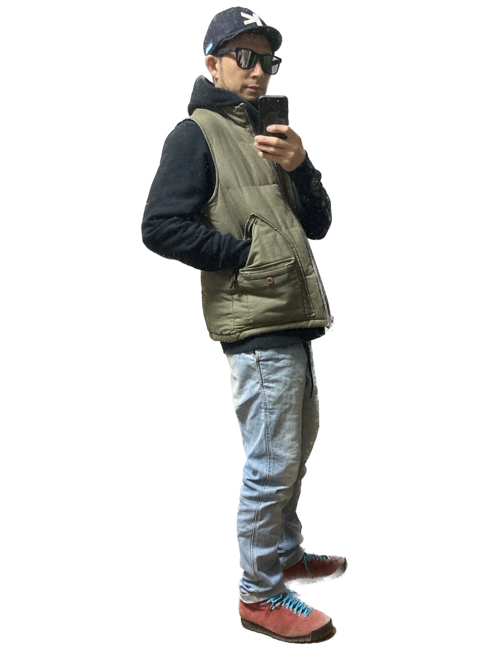 グリーン系のベスト、ブラック系のパーカー、ブルー系のデニムパンツを着用したメンズの冬コーディネートの2枚目の写真